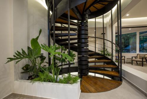 a spiral staircase in a house with plants at Ladiko Suites - Faliraki in Faliraki