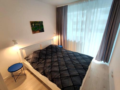sypialnia z łóżkiem w pokoju z oknem w obiekcie Apartament Słoneczny Brzeg w Kołobrzegu