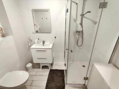 łazienka z prysznicem, umywalką i toaletą w obiekcie Apartament Słoneczny Brzeg w Kołobrzegu