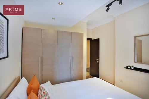 a bedroom with a large wooden closet and a bed at Prime Select Point 90 Mall in Cairo