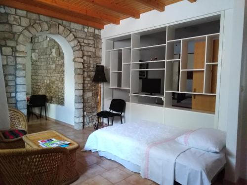 a bedroom with a bed and a stone wall at Apartment Bibić - Hvar center old town in Hvar