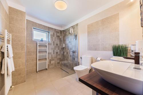 a bathroom with a tub and a toilet and a sink at Orchard Villa in Braşov