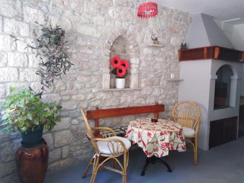 a table and chairs in a room with a stone wall at Apartment Bibić - Hvar center old town in Hvar