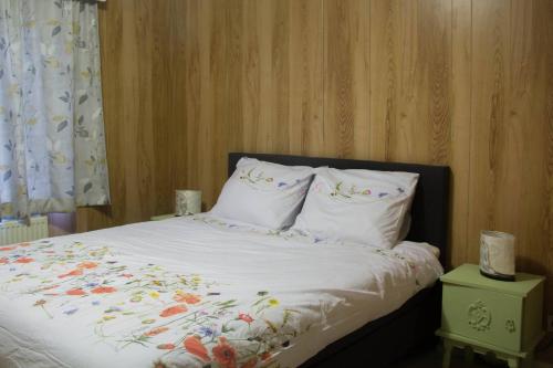 1 dormitorio con 1 cama con sábanas y almohadas blancas en 'T ONDERDAK, en Lommel
