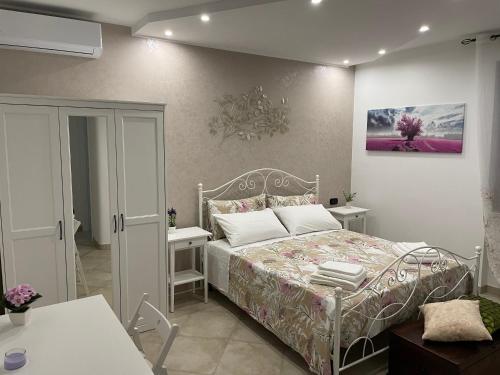 - une chambre avec un lit et 2 tables blanches dans l'établissement casa Belcolle, à Putignano