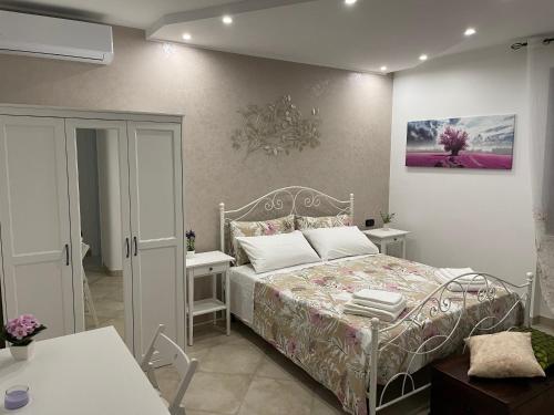 a bedroom with a bed and two white tables at casa Belcolle in Putignano