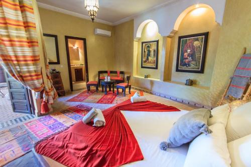 a bedroom with a large bed with red sheets at Riad Nabila in Marrakesh