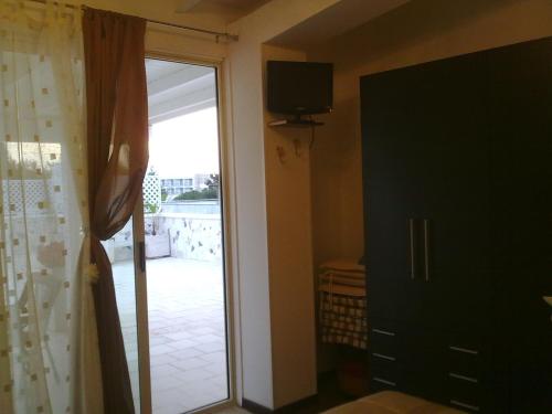 una puerta a una habitación con TV y una puerta corredera de cristal en Gallipoli a Rivabella Beach, en Gallipoli