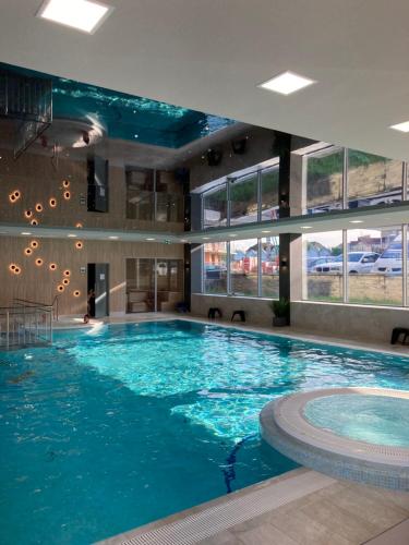 a large swimming pool with blue water in a building at Apartament K&K Klifowa Rewal in Rewal