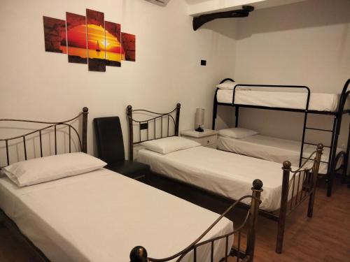 a room with three beds and a painting on the wall at Casa Janas Affittacamere Bed & Breakfast in Piscinas