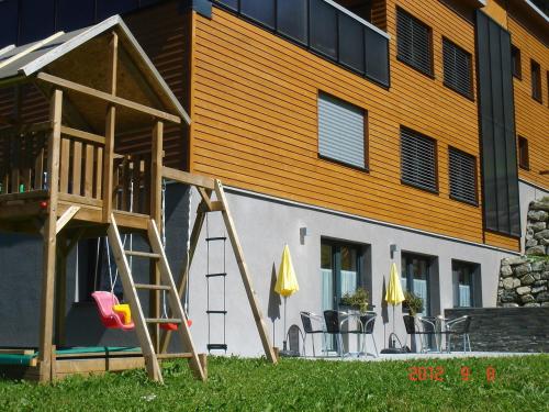 a playground with a wooden ladder and a building at Haus Elisabeth in Gaschurn