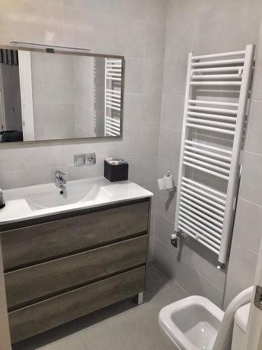 a bathroom with a sink and a mirror and a toilet at Galicia47 in Zamora
