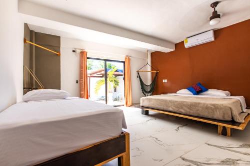 a bedroom with two beds and a window at Howlita Tulum - Adult Only in Tulum