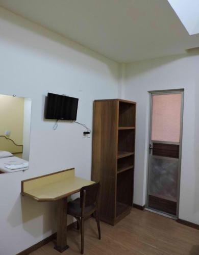 a room with a desk and a tv on a wall at Hotel Belas Artes in Rio de Janeiro