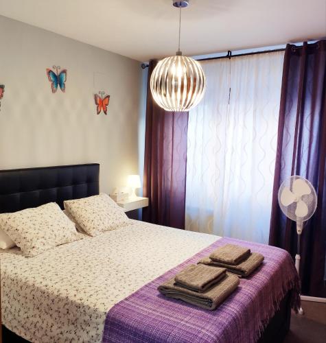 a bedroom with a bed with towels on it at El Balconcito de San Millan in Segovia