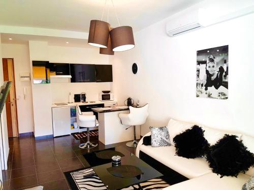 uma sala de estar com um sofá branco e uma cozinha em Cannes la Croisette, Baoli 4 beds, balcony,parking em Cannes