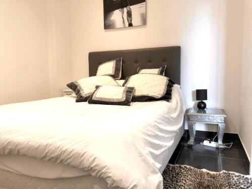 um quarto com uma cama com lençóis brancos e almofadas em Cannes la Croisette, Baoli 4 beds, balcony,parking em Cannes
