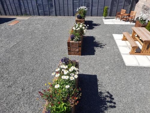 a garden with flowers in wooden boxes and benches at Park View house on NC500 in Wick