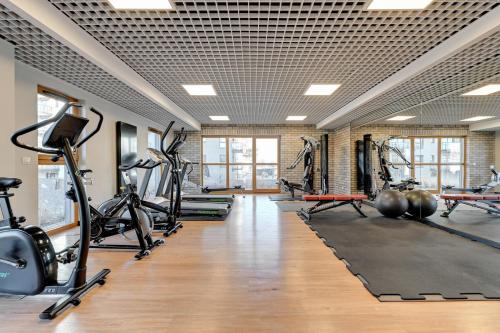 a gym with treadmills ellipticals and exercise bikes at Royal Sand Apartment in Gdańsk