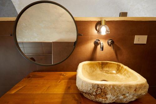 a bathroom with a stone sink and a mirror at Petra - Country House in Monteroni di Lecce