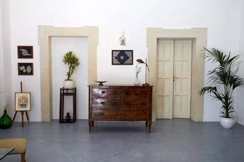 a room with a dresser and two potted plants at Petra - Country House in Monteroni di Lecce