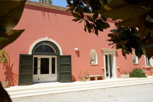 a red building with a door in front of it at Petra - Country House in Monteroni di Lecce
