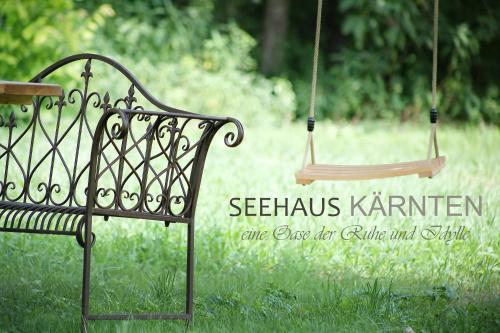 a bench sitting in the grass next to a swing at Seehaus Kärnten in Saager