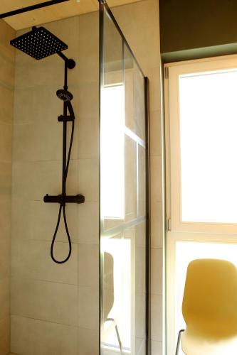 a shower in a bathroom with a yellow chair at Seehaus Kärnten in Saager