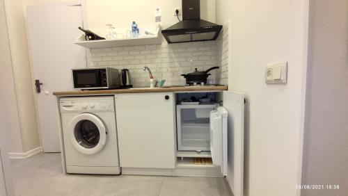a kitchen with a washing machine and a microwave at Piano Foyer Apartments at City Center in Tbilisi City