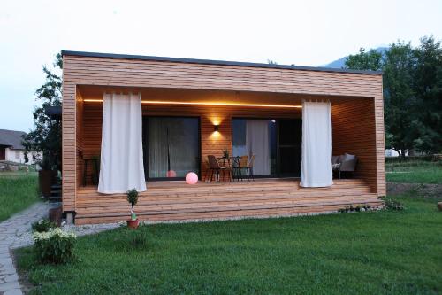 a small cabin with a deck with a table at Seehaus Kärnten in Saager