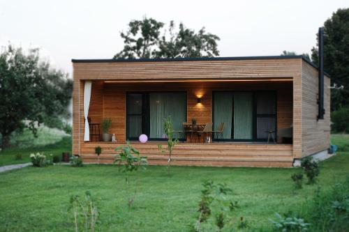 a small cabin in a field with a grass yard at Seehaus Kärnten in Saager