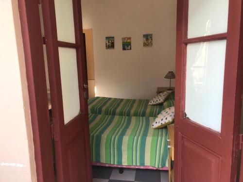 Habitación pequeña con cama y puerta en Posada Casa de Borgoña en Salta