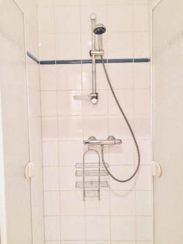 a shower in a bathroom with white tiles at Bijou Brussels > Parvis St Pierre in Brussels