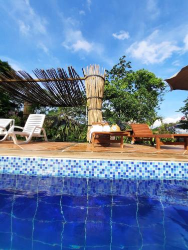 a pool with a table and a bench next to aiki at Sendero del Rio Finca Hotel in San Rafael
