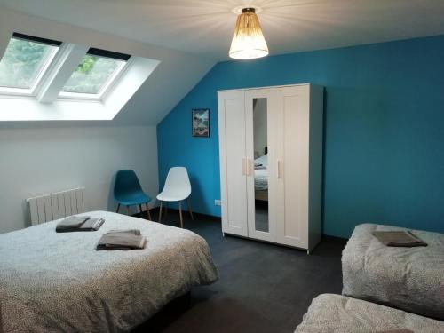 ein Schlafzimmer mit 2 Betten und einer blauen Wand in der Unterkunft La Voilerie in Fécamp