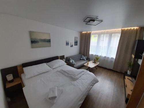 1 dormitorio con 1 cama blanca grande y 1 sofá en Private Apartment Rozvadov en Rozvadov