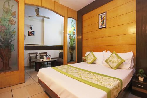 a bedroom with a bed with a wooden headboard at Hotel Sun Village Near New Delhi Railway Station in New Delhi
