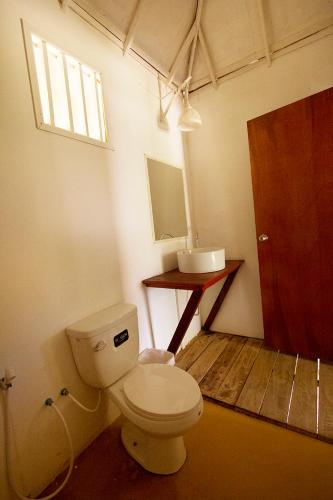 a bathroom with a toilet and a sink at Rabbit Bungalow in Ko Phayam