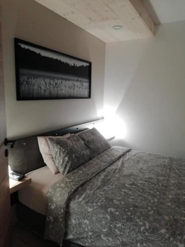 a bedroom with a bed and a picture on the wall at Lu ptite cwane dol Lydie in Malmedy