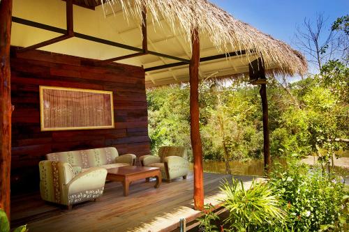 a patio with a couch and chairs on a wooden deck at Rabbit Bungalow in Ko Phayam