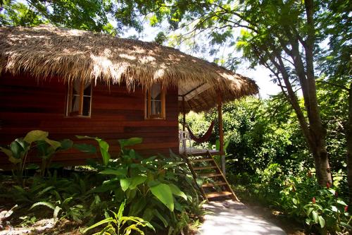 a small wooden hut with a straw roof at Rabbit Bungalow in Ko Phayam