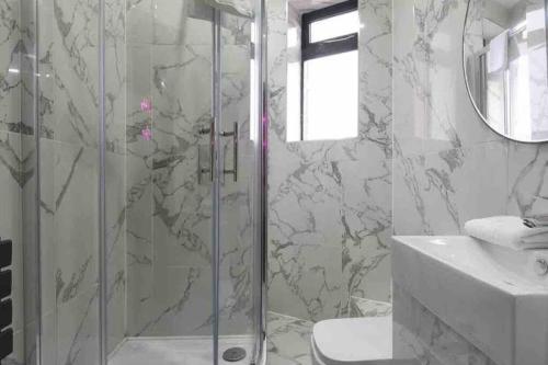 een badkamer met een douche en een wastafel bij Casa Nomade Penthouse slps 20 people Mcr centre in Manchester