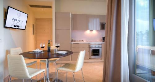 a dining room table with white chairs and wine glasses at Forte16 View & SPA in Florence