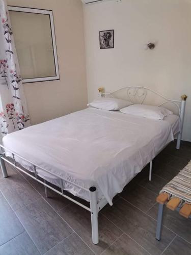 a bedroom with a white bed with a white bedspread at Studio Zenap in Agios Georgios