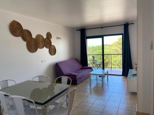 sala de estar con mesa y sofá en La Mundial Formentera en Es Pujols