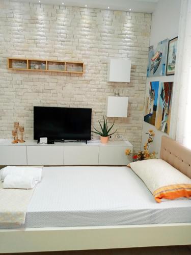 een slaapkamer met een groot bed en een televisie bij Unejs Apartment in Berat