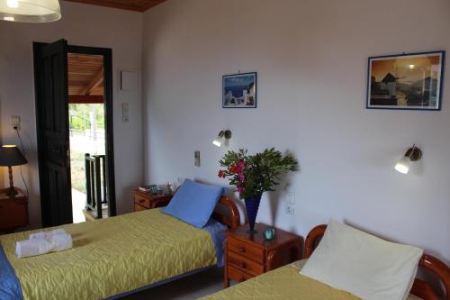 una camera con due letti e un vaso di fiori di Gianna's House a Stavros