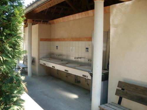- une salle de bains avec deux lavabos dans un bâtiment dans l'établissement Camping les Silhols, à Lagorce