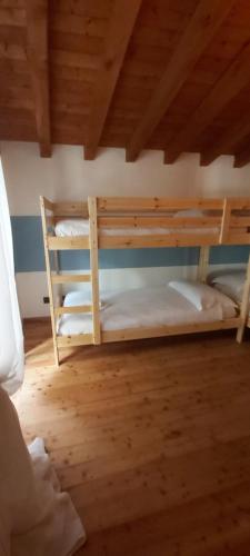 two bunk beds in a room with a wooden ceiling at CASA LUDIZZO in Bovegno