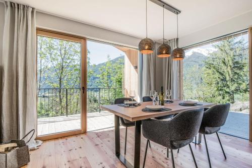 a dining room with a table and chairs and a large window at Chalet & Appartement Zingerlehof Trens in Campo di Trens